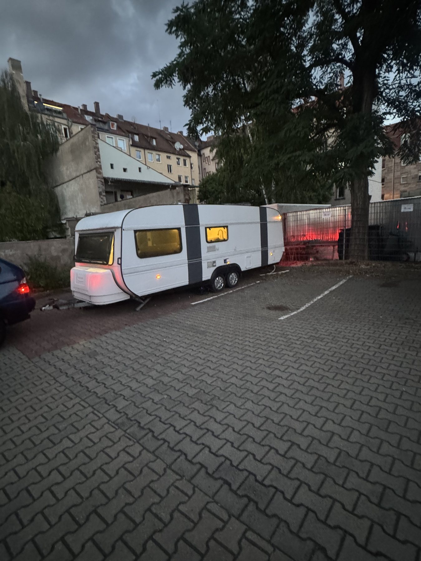 Der Caravan am Abend mit leuchtenden Fenstern im Hinterhof