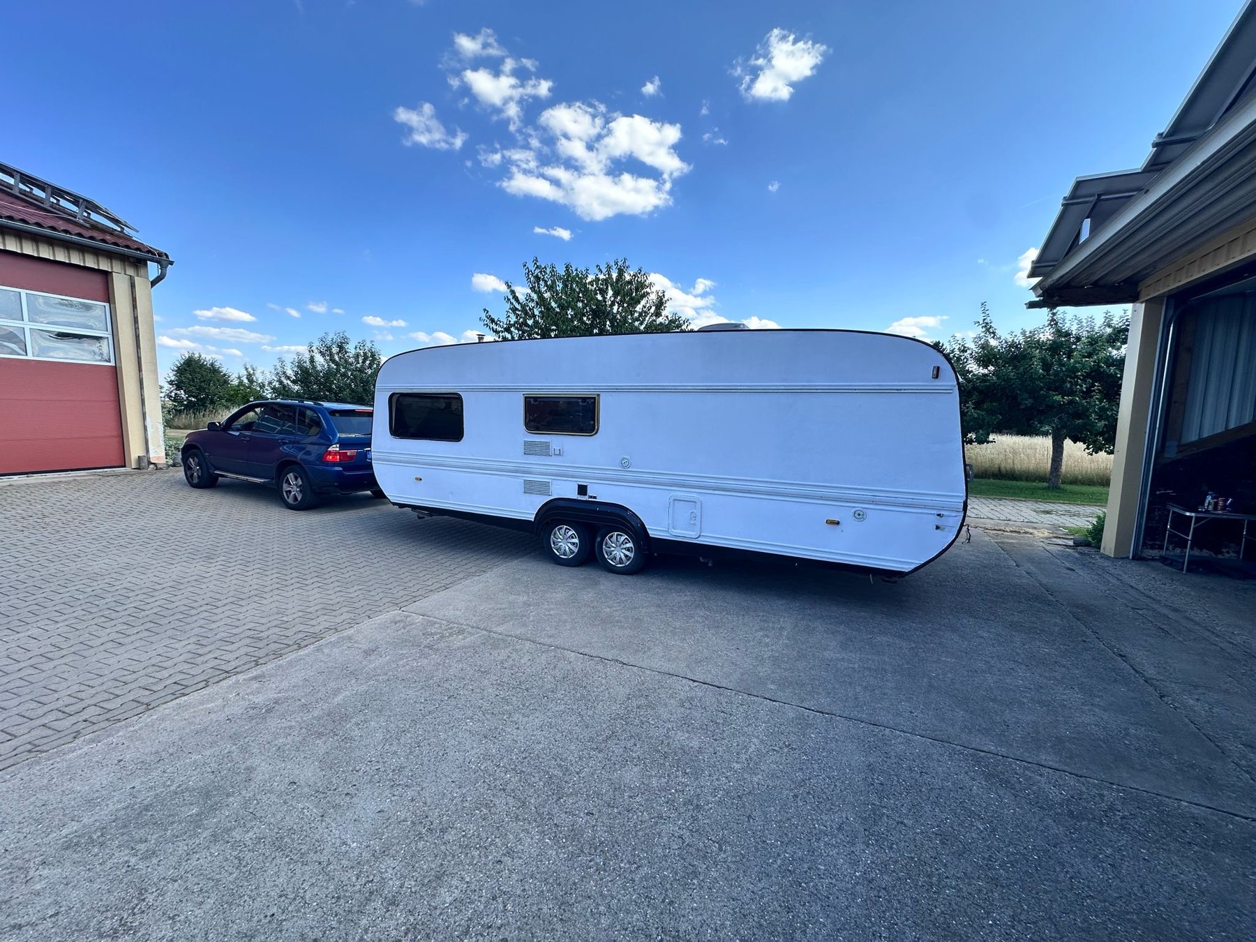 Der weiße Caravan in der Seitenansicht vor der Halle